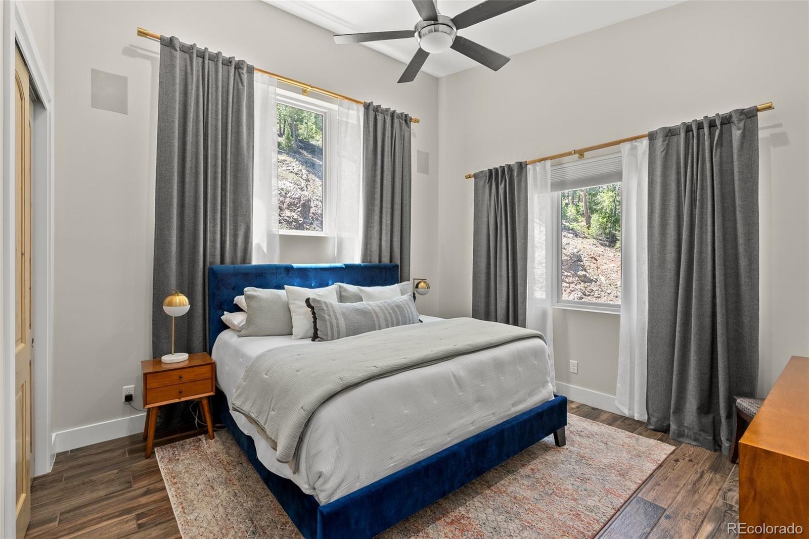 9218 South Turkey Creek Road Morrison, CO 80465 - Photo 8 of 44 a bedroom with a bed lamp and a window