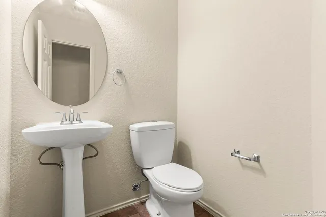 a bathroom with a toilet sink and mirror