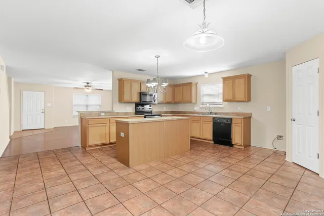 a kitchen with a sink window and cabinets