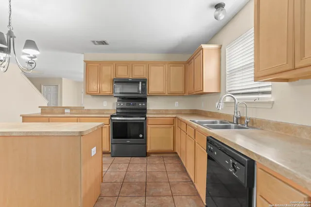a kitchen with a sink cabinets and stainless steel appliances