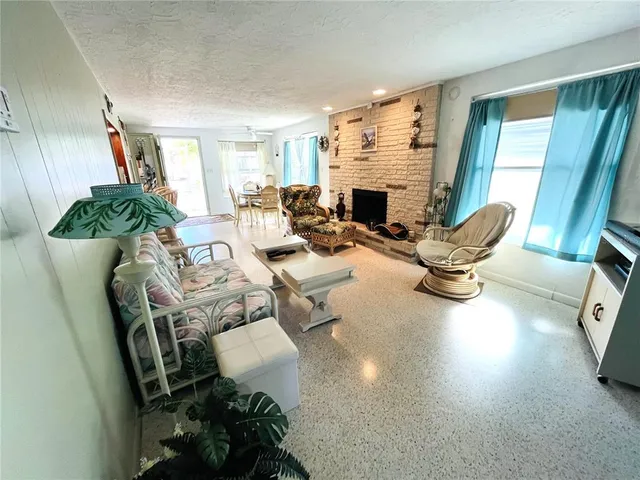 a living room with furniture a fireplace and a floor to ceiling window