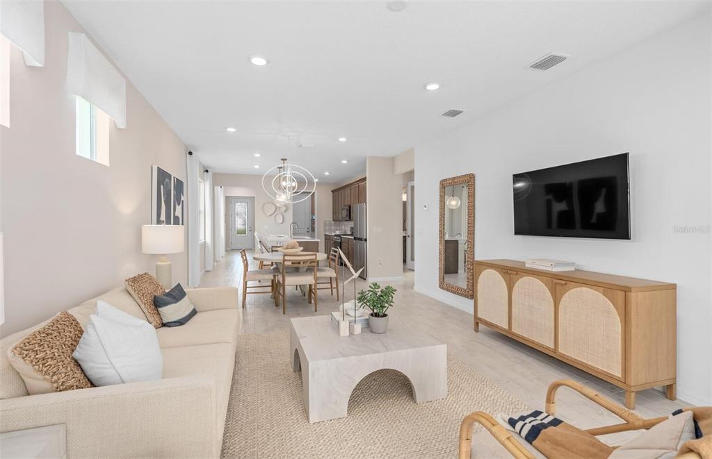 2386 Lily Bloom Road St. Cloud, FL 34771 - Photo 11 of 14 a living room with furniture kitchen view and a flat screen tv
