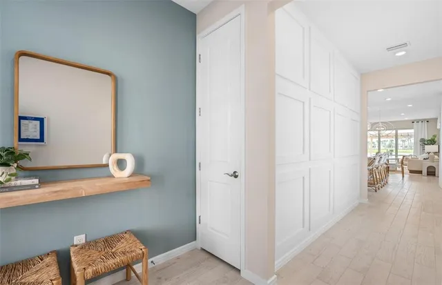 a kitchen with stainless steel appliances kitchen island granite countertop a stove a sink a oven a dining table and chairs with wooden floor