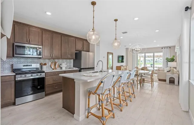 a kitchen with granite countertop stainless steel appliances a stove a microwave and sink