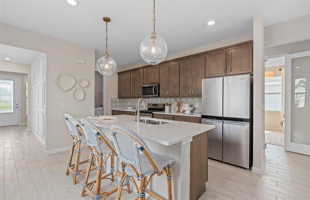 2386 Lily Bloom Road St. Cloud, FL 34771 - Photo 7 of 14 a kitchen with stainless steel appliances granite countertop a refrigerator a stove a sink dishwasher a refrigerator with a dining table and chairs