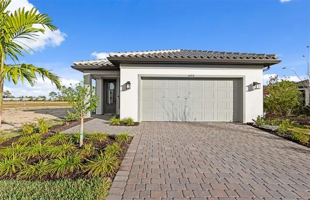 a view of a house with a patio and a yard