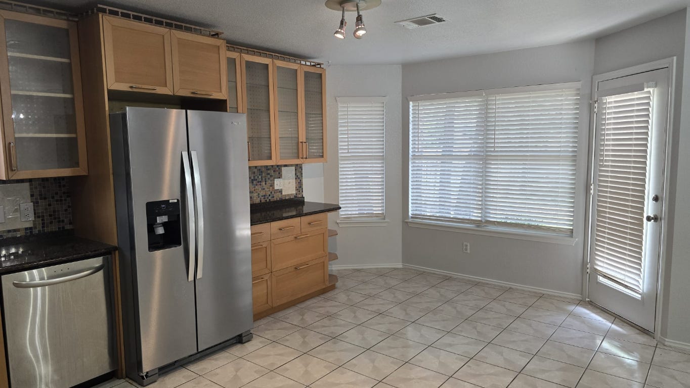 7704 Earp Way Austin, TX 78729 - Photo 5 of 20 a kitchen with a refrigerator and a sink