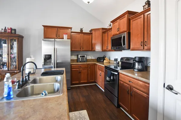 a kitchen with stainless steel appliances granite countertop a sink stove and refrigerator