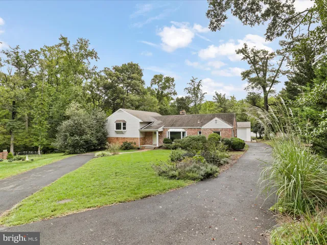 a front view of a house with a garden and trees