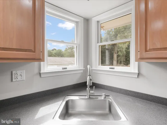 a view of hallway with window and wooden floor