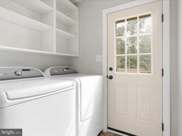 a view of an empty room with a fireplace and a window