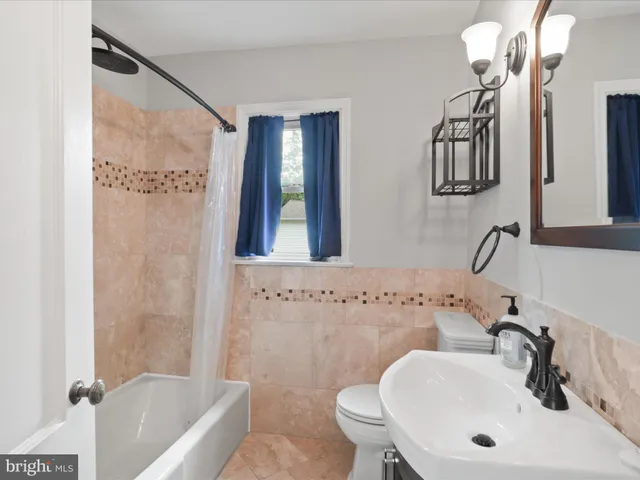 a bathroom with a sink a toilet a mirror and shower