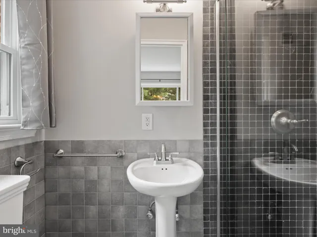 a view of a room with wooden floor a ceiling fan and windows
