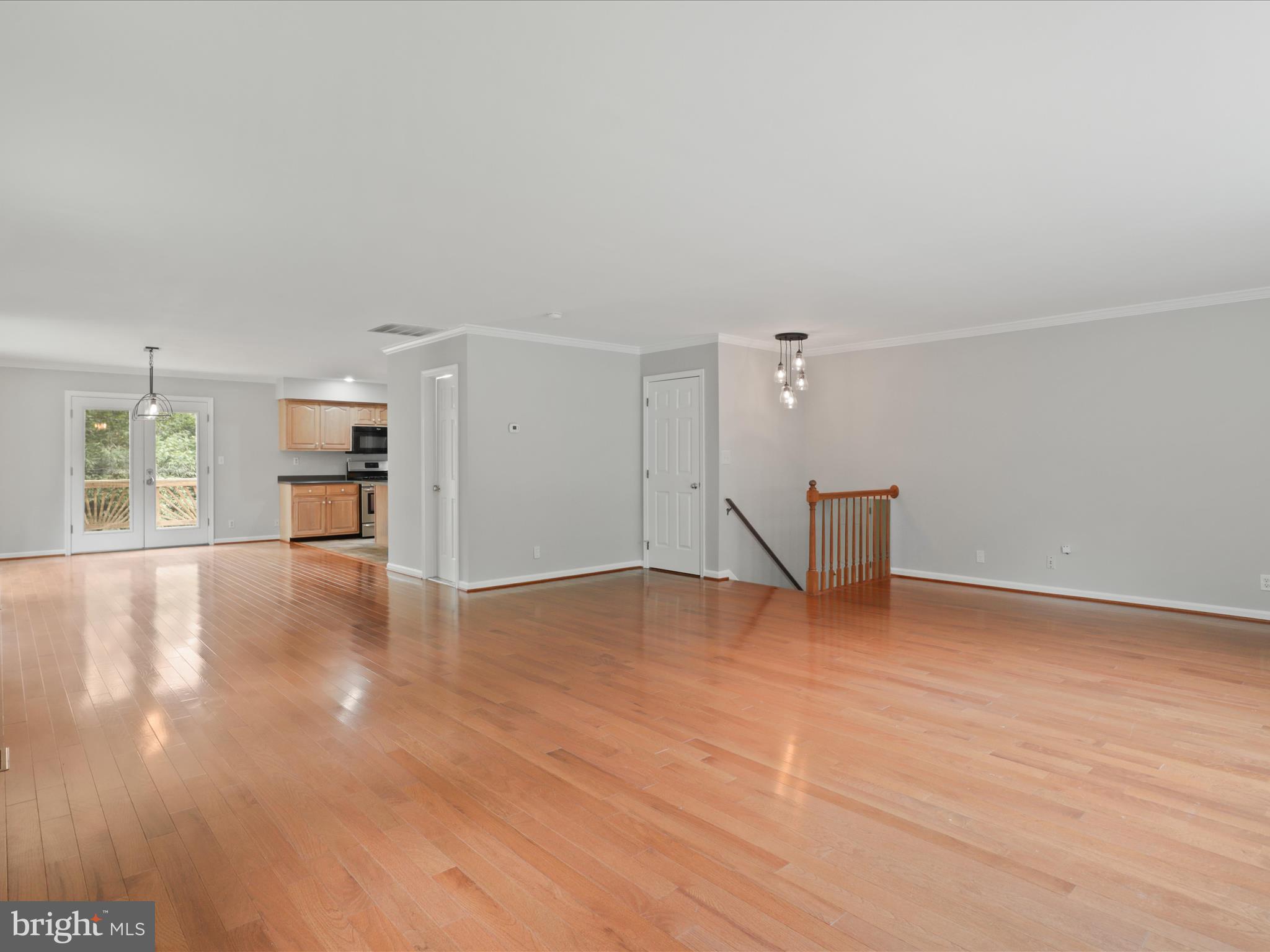 7533 Hollindale Court Alexandria, VA 22306 - Photo 33 of 78 a view of empty room with wooden floor and kitchen view
