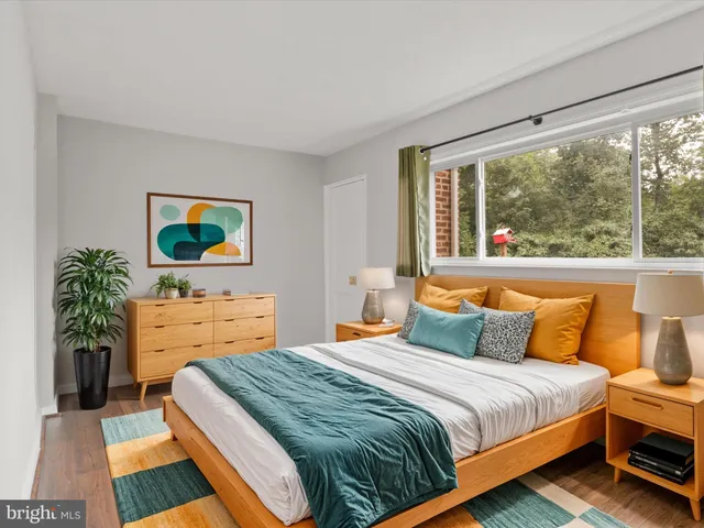 a bedroom with a bed and a dresser next to a window