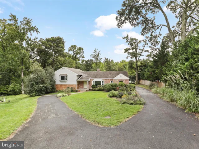 a front view of a house with a yard and trees