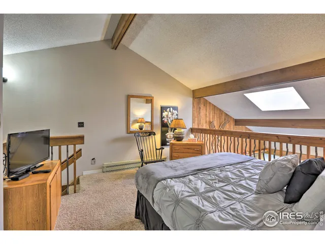 a bedroom with a bed window and a flat screen tv