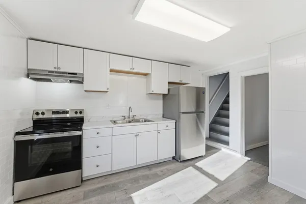 a kitchen with stainless steel appliances a stove refrigerator sink and cabinets