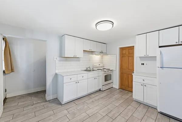 a kitchen with white cabinets and white appliances