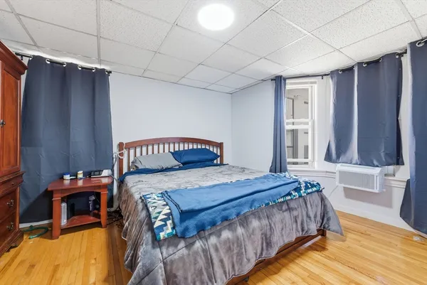 a bedroom with a bed and a table with wooden floor