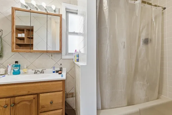 a bathroom with a sink a window and a washer dryer