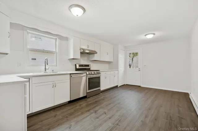 a kitchen with a sink cabinets and wooden floor