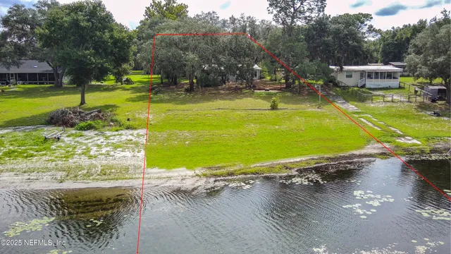 a view of a swimming pool with a yard and trees in the background