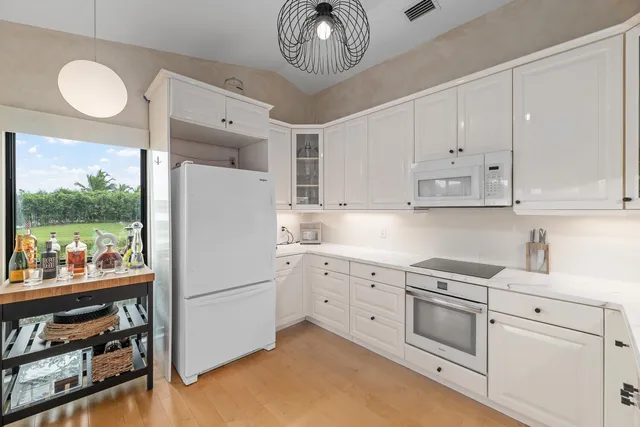 a kitchen with white cabinets and white appliances