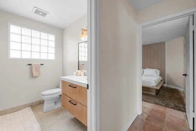a bathroom with a toilet a sink and a window
