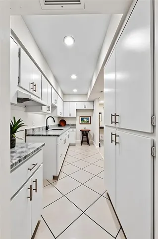 a kitchen with stainless steel appliances kitchen island a refrigerator sink and cabinets