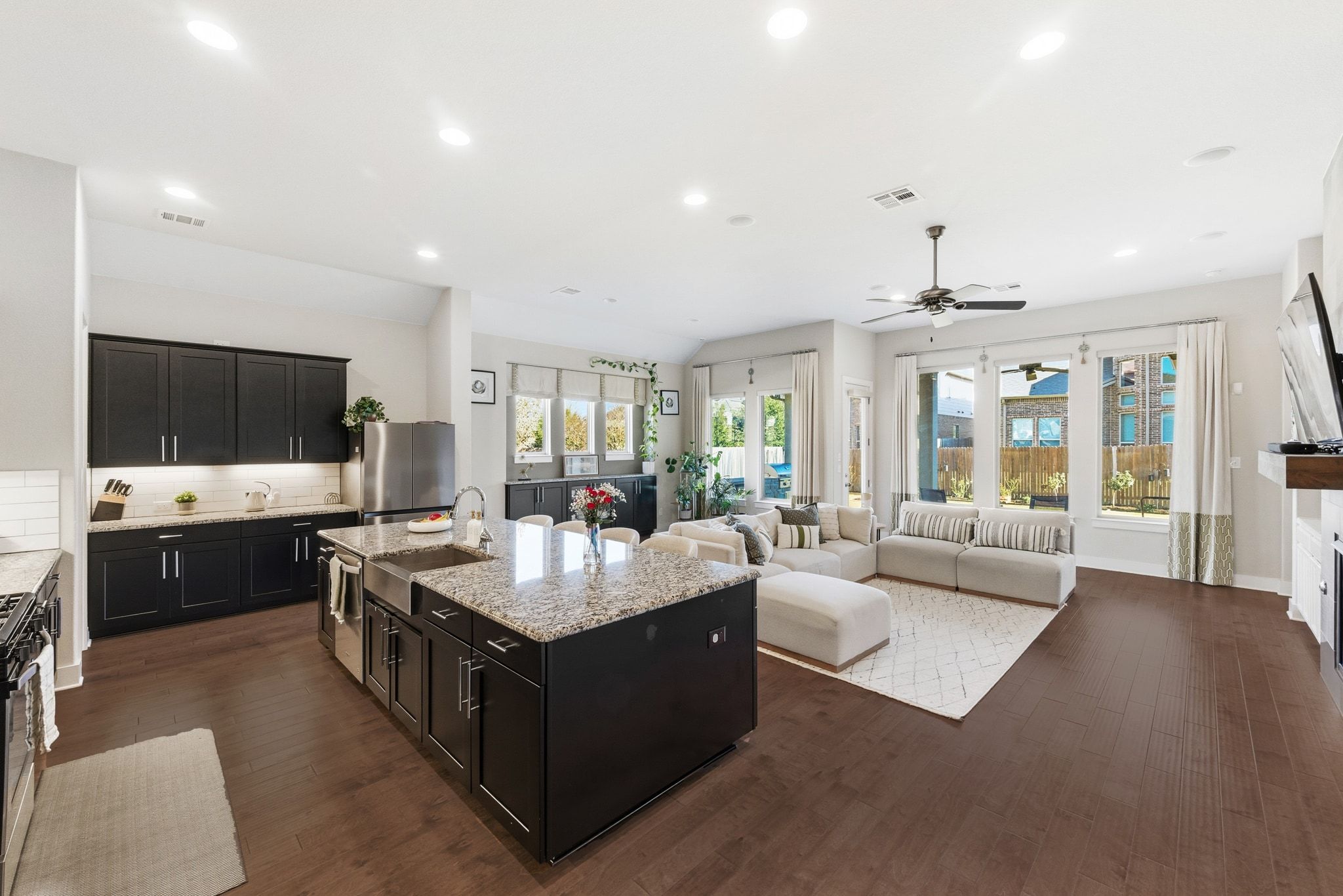108 Leon Loop Liberty Hill, TX 78642 - Photo 12 of 39 Kitchen featuring dark cabinets, light stone countertops, dark wood-style floors, and recessed lighting