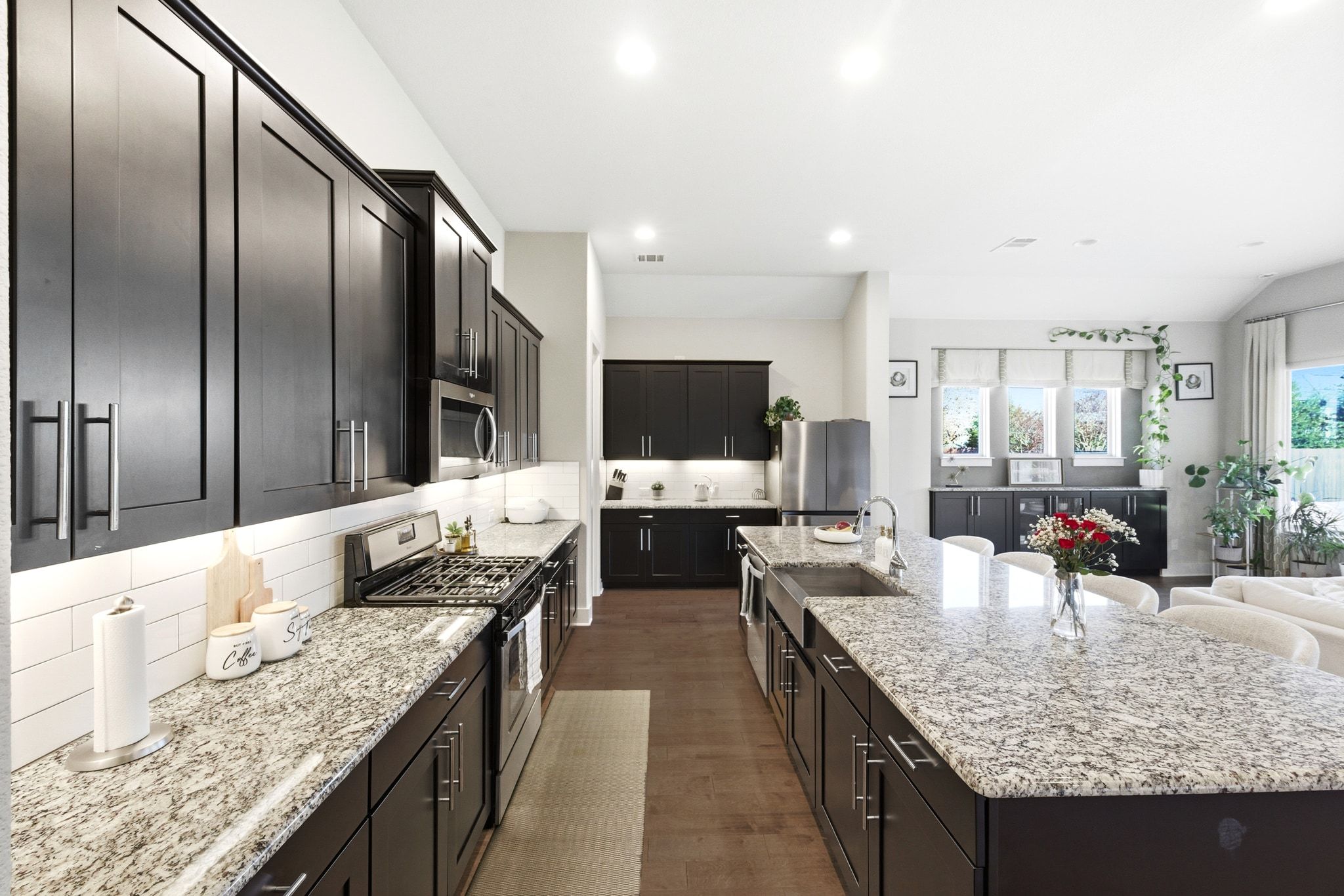 108 Leon Loop Liberty Hill, TX 78642 - Photo 13 of 39 Kitchen featuring appliances with stainless steel finishes, light stone countertops, tasteful backsplash, dark wood-style floors, and recessed lighting