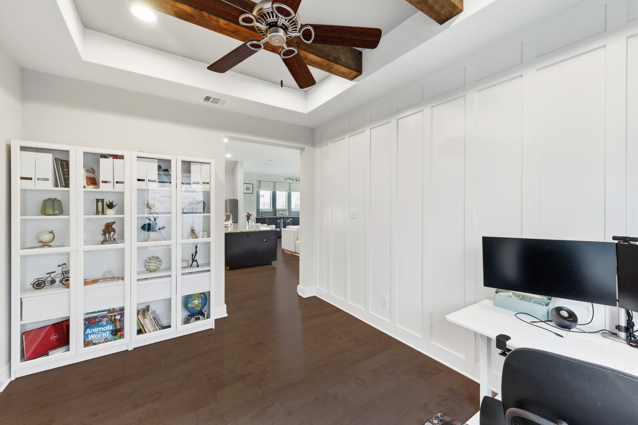 108 Leon Loop Liberty Hill, TX 78642 - Photo 16 of 39 Home office featuring a raised ceiling, dark wood-style flooring, ceiling fan, and a decorative wall