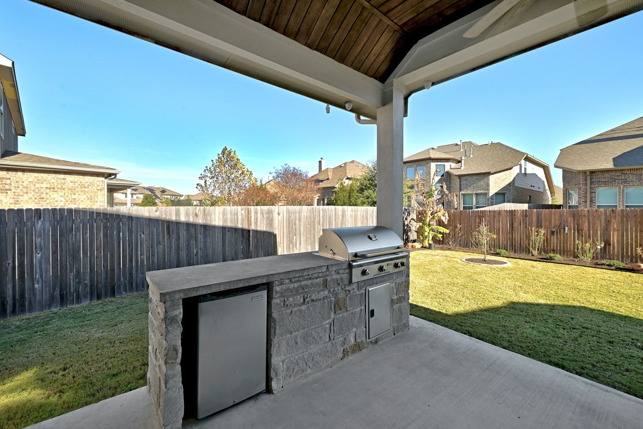 108 Leon Loop Liberty Hill, TX 78642 - Photo 26 of 39 Fenced backyard with an outdoor kitchen, a patio, and a residential view