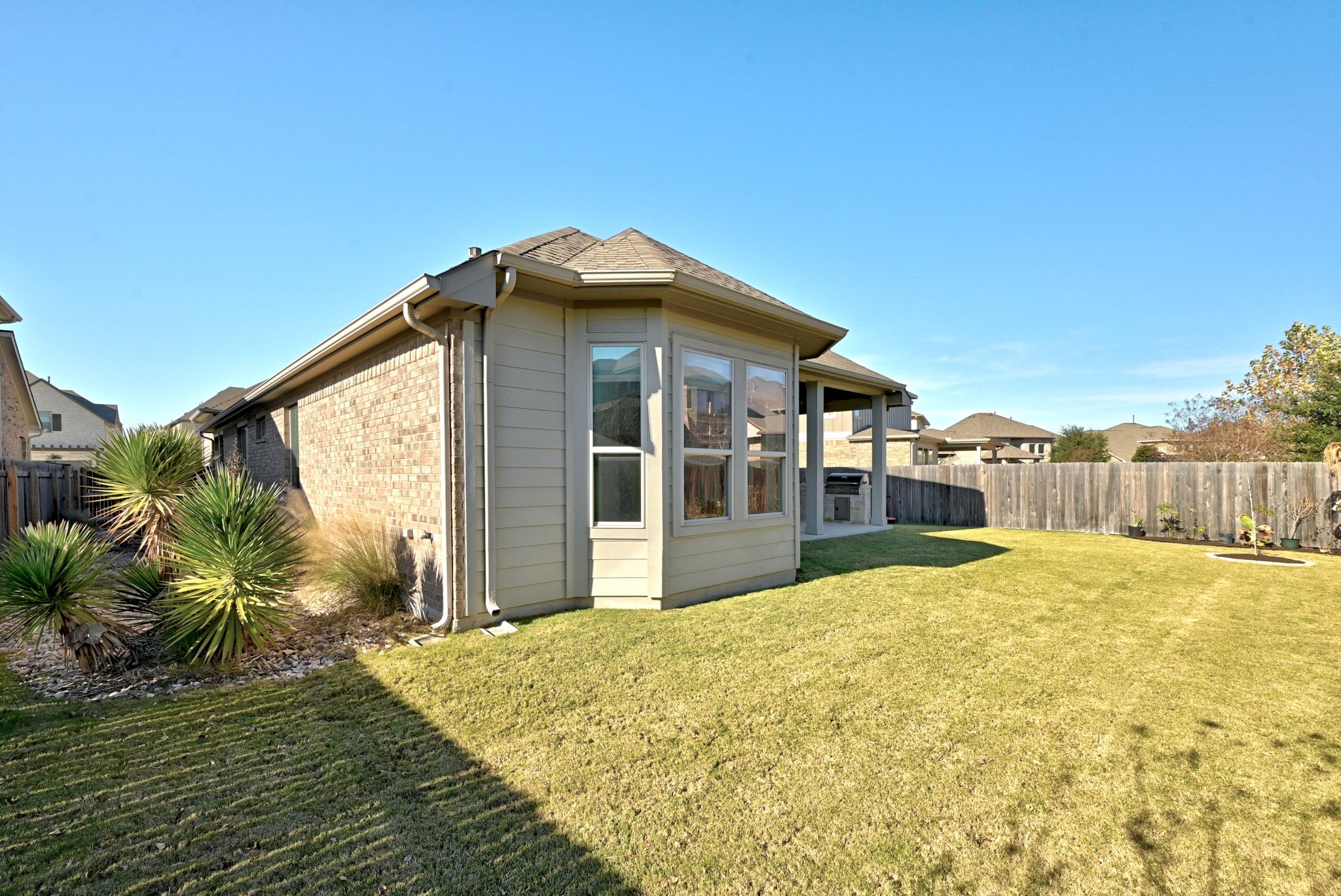 108 Leon Loop Liberty Hill, TX 78642 - Photo 30 of 39 Back of property featuring a fenced backyard and brick siding