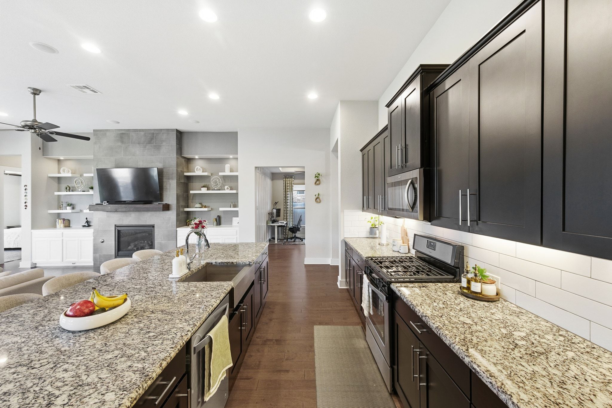 108 Leon Loop Liberty Hill, TX 78642 - Photo 39 of 39 Kitchen featuring stainless steel appliances, light stone countertops, open floor plan, dark wood-style flooring, and recessed lighting