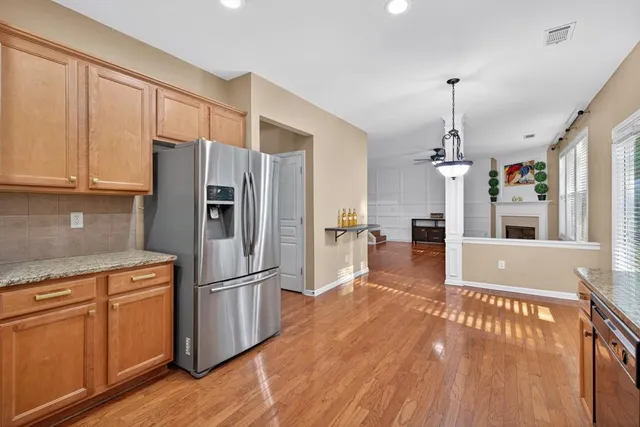 a kitchen with stainless steel appliances granite countertop a refrigerator a sink and a stove