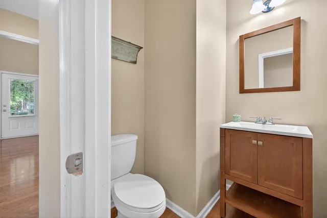 a bathroom with a toilet sink vanity and mirror