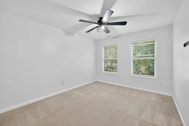 an empty room with a window and a fan