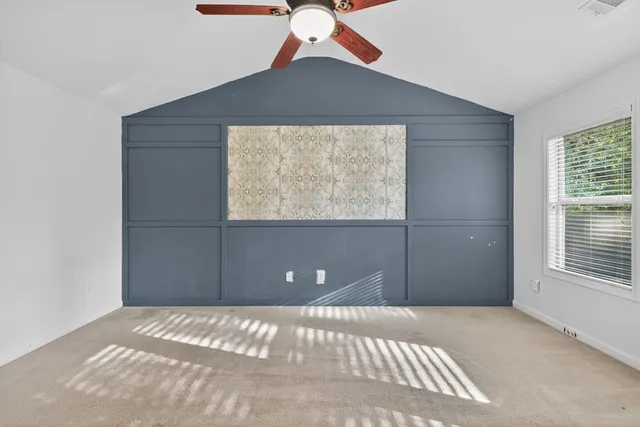 a view of a room with a ceiling fan and window