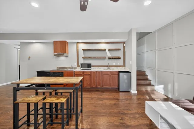 a kitchen with granite countertop a stove a sink and a refrigerator