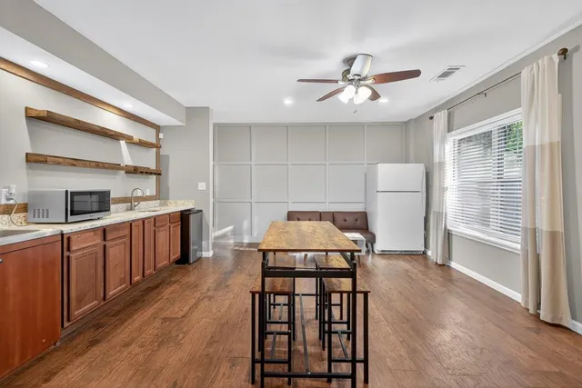 a kitchen that has a lot of cabinets in it and wooden floors