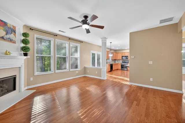 a view of empty room with wooden floor and fireplace