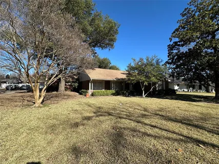 a front view of a house with a yard and trees