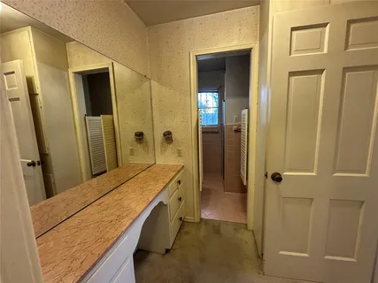 a bathroom with a granite countertop sink and a mirror