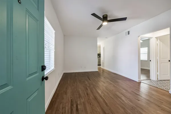 a view of a livingroom with wooden floor and a ceiling fan
