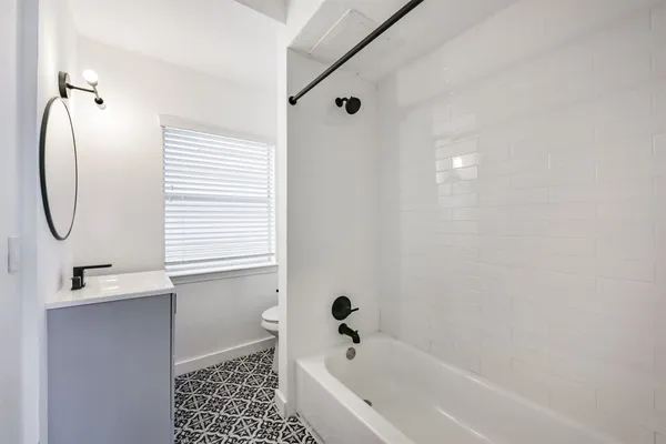a bathroom with a tub sink and a window