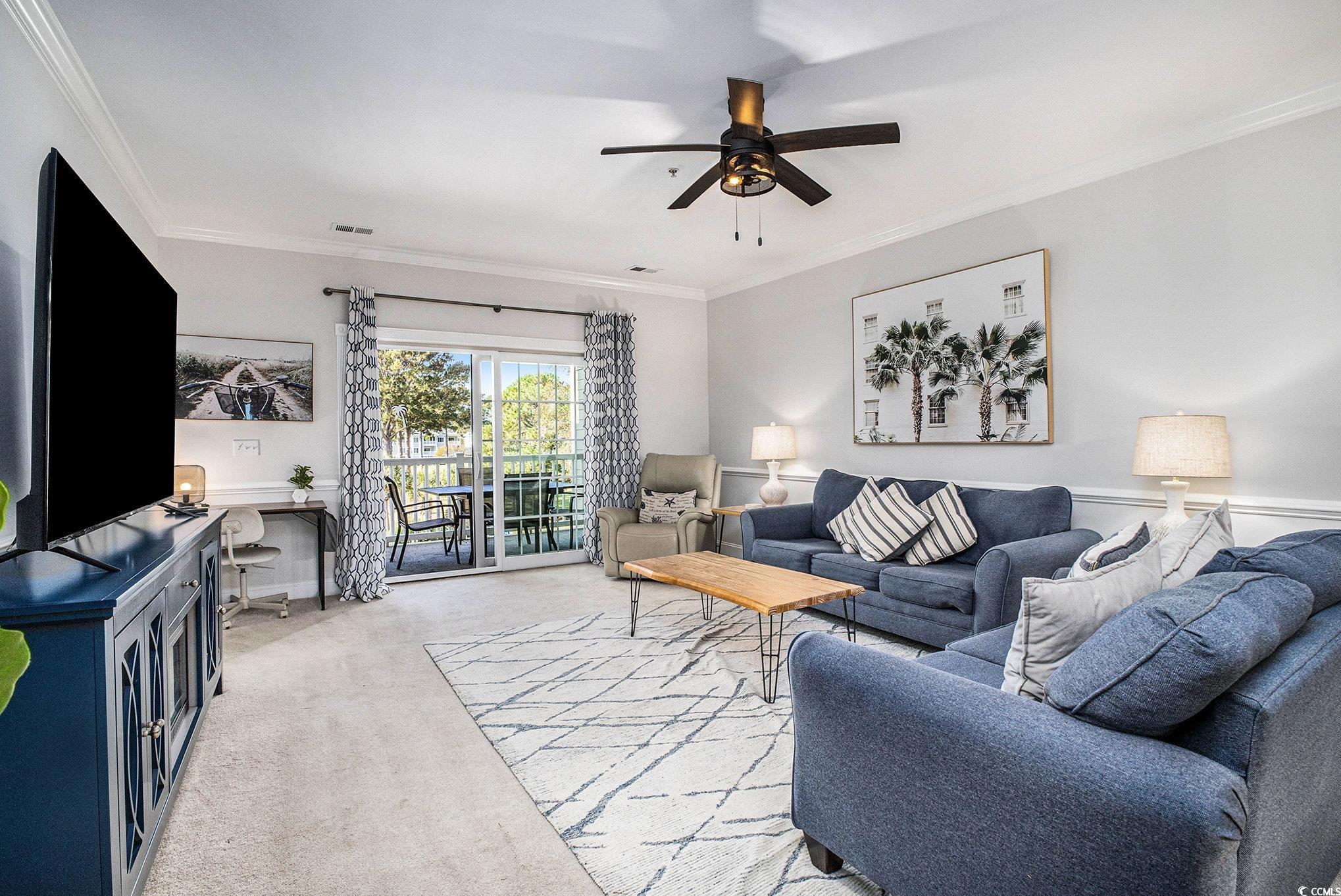 4894 Luster Leaf Circle, Unit 303 Myrtle Beach, SC 29577 - Photo 10 of 31 Carpeted living room featuring crown molding and a ceiling fan