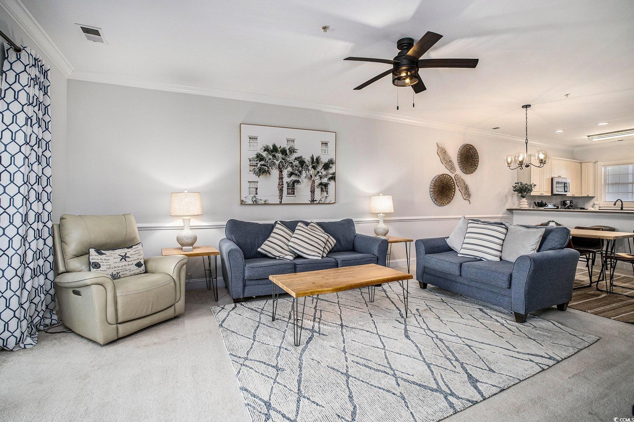 4894 Luster Leaf Circle, Unit 303 Myrtle Beach, SC 29577 - Photo 13 of 31 Carpeted living area featuring ornamental molding, a chandelier, and ceiling fan