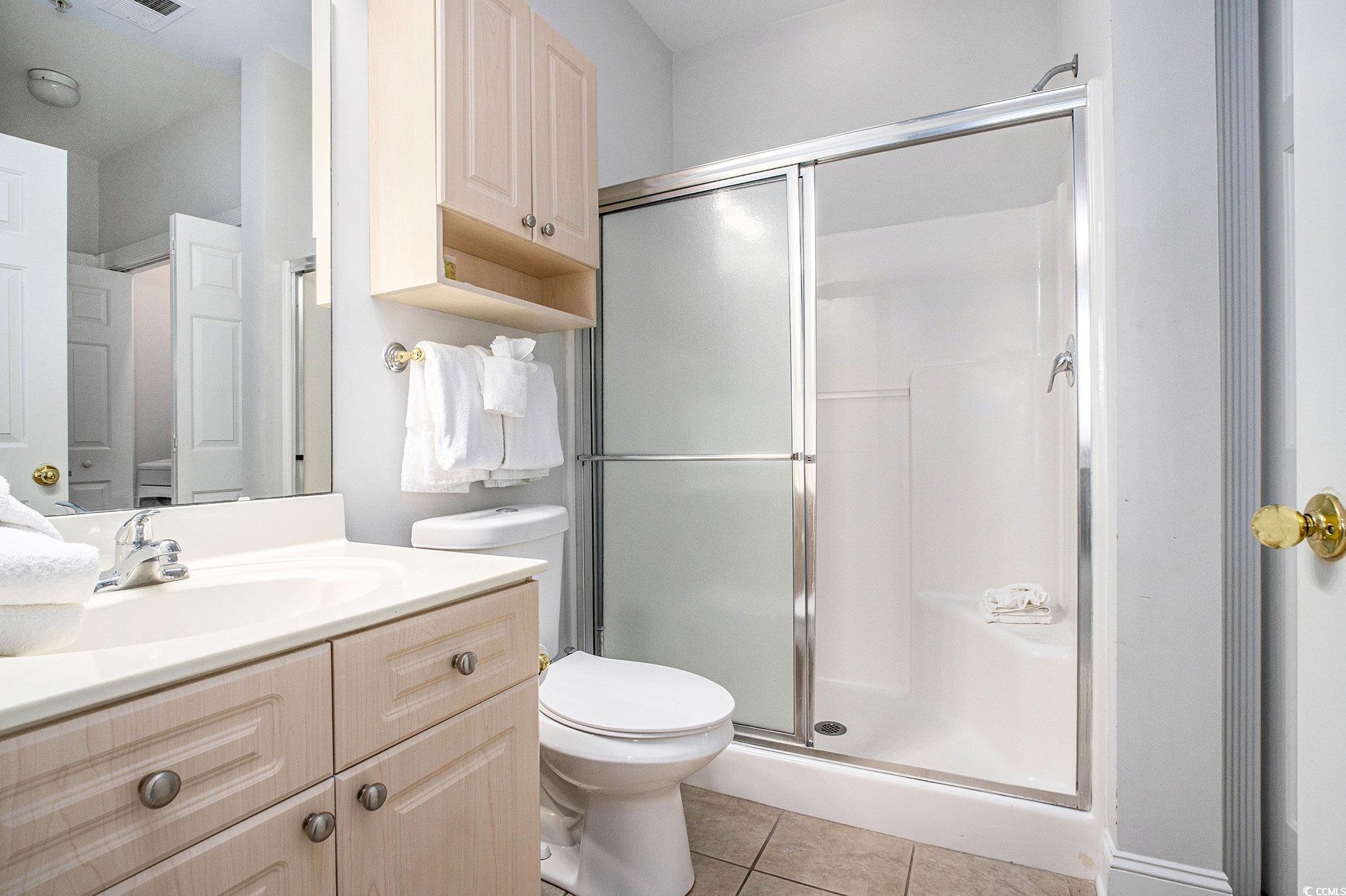 4894 Luster Leaf Circle, Unit 303 Myrtle Beach, SC 29577 - Photo 18 of 31 Full bath with light tile patterned flooring, a shower stall, and vanity